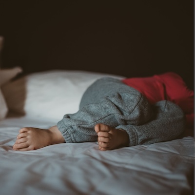 A child's feet in a comfy bed