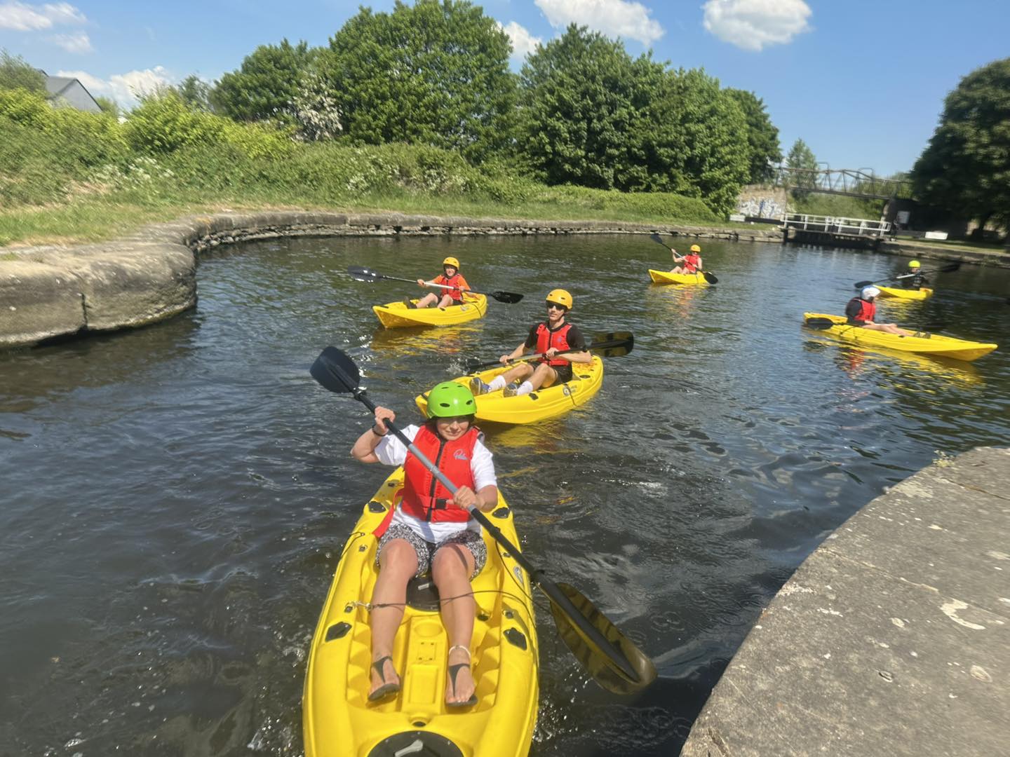 A group of mixed ages kayaking on a canal waterway