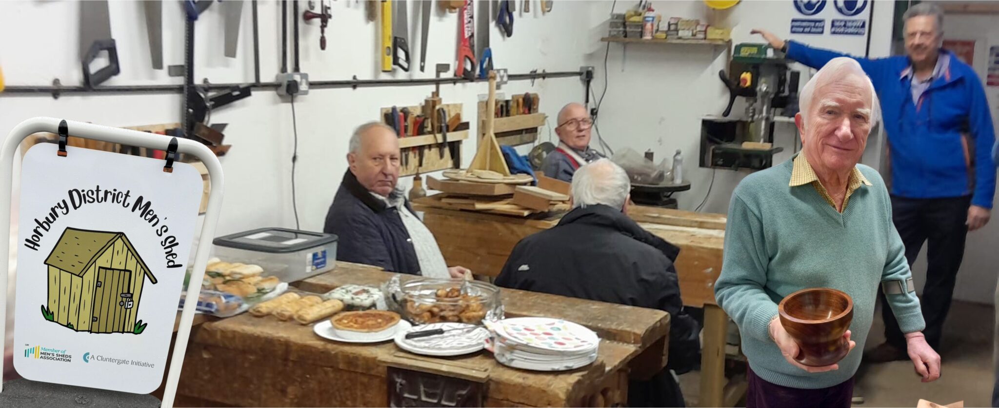 A workshop showing a collection of gentlemen who are taking a break, featuring a man smiling, showing the camera a wooden bowl he has made
